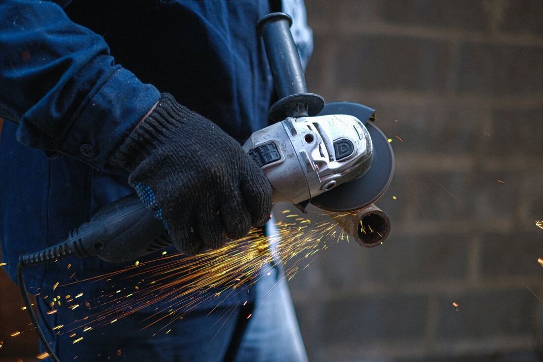 Un carpintero de aluminio serrando un tabo de metal. Foto tomada en Vigo, Pontevedra.